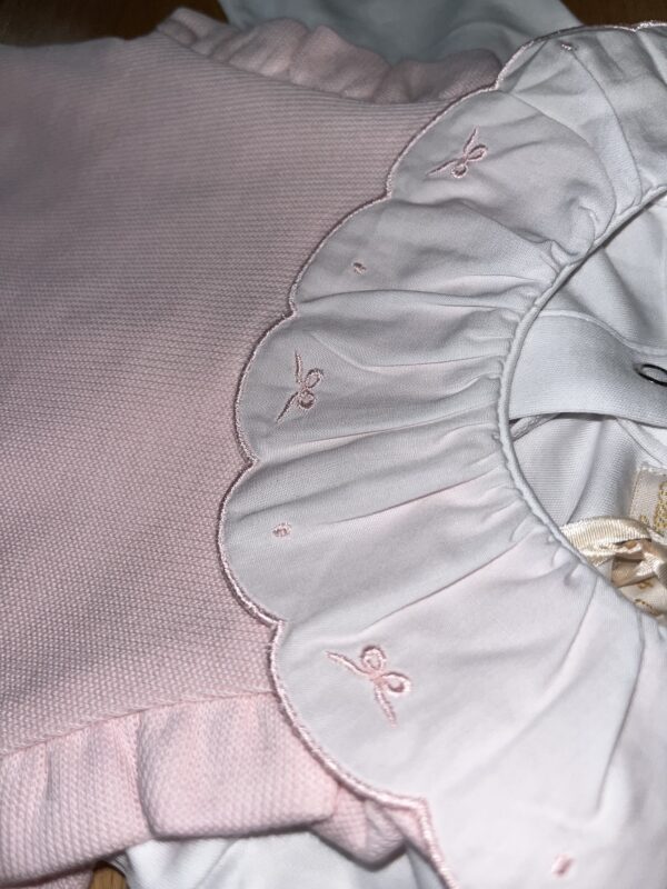 Pink baby dress with embroidered collar details.