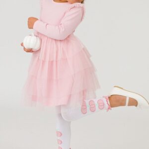 Girl in pink dress holding white pumpkin