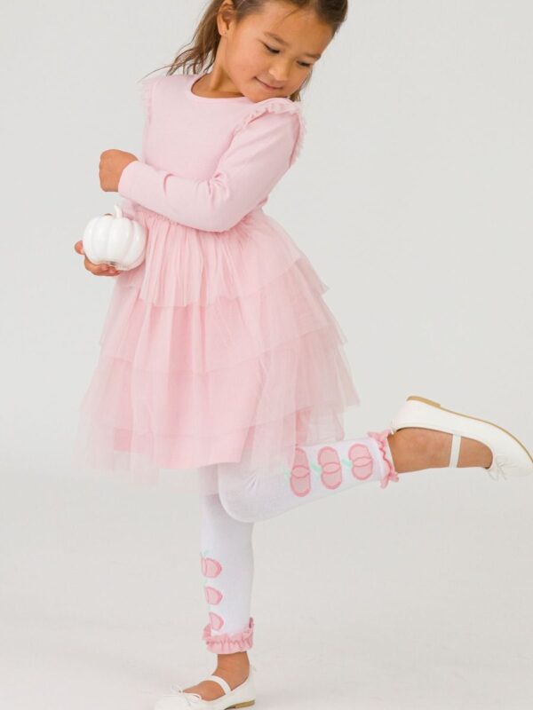 Girl in pink dress holding white pumpkin