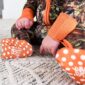 Baby in camo outfit and orange booties on rug.