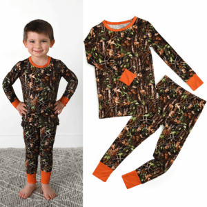 Child in camouflage pajamas with orange cuffs