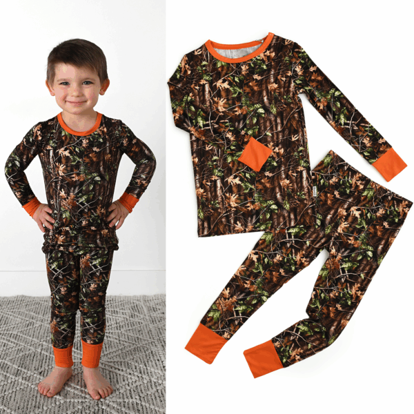 Child in camouflage pajamas with orange cuffs