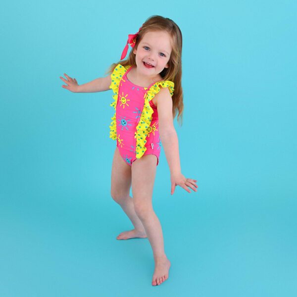 Child in bright swimsuit posing playfully