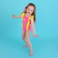 Child in bright swimsuit posing playfully