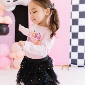 Child wearing 'Hocus Pocus' Halloween shirt, star skirt