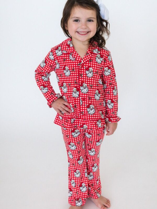 Child in red Santa pajamas smiling