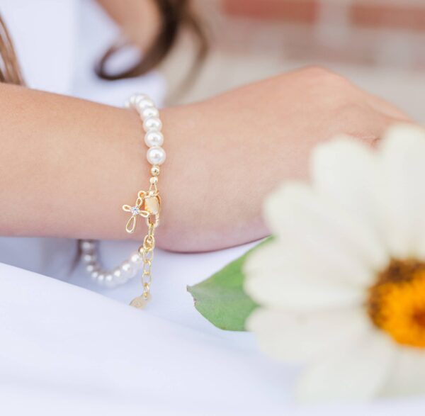 Pearl bracelet with floral charm on wrist