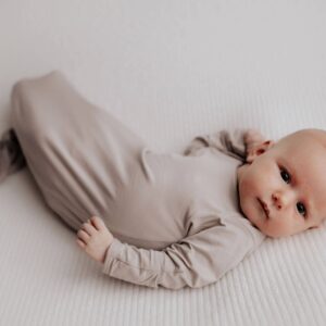 Baby lying on a white blanket.
