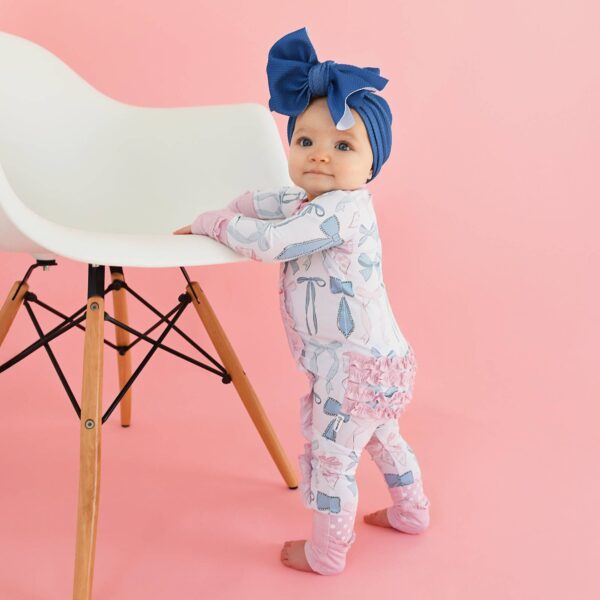 gigi and max samantha bows ruffle zip bamboo sleeplies little outfit Baby in blue bow standing by chair