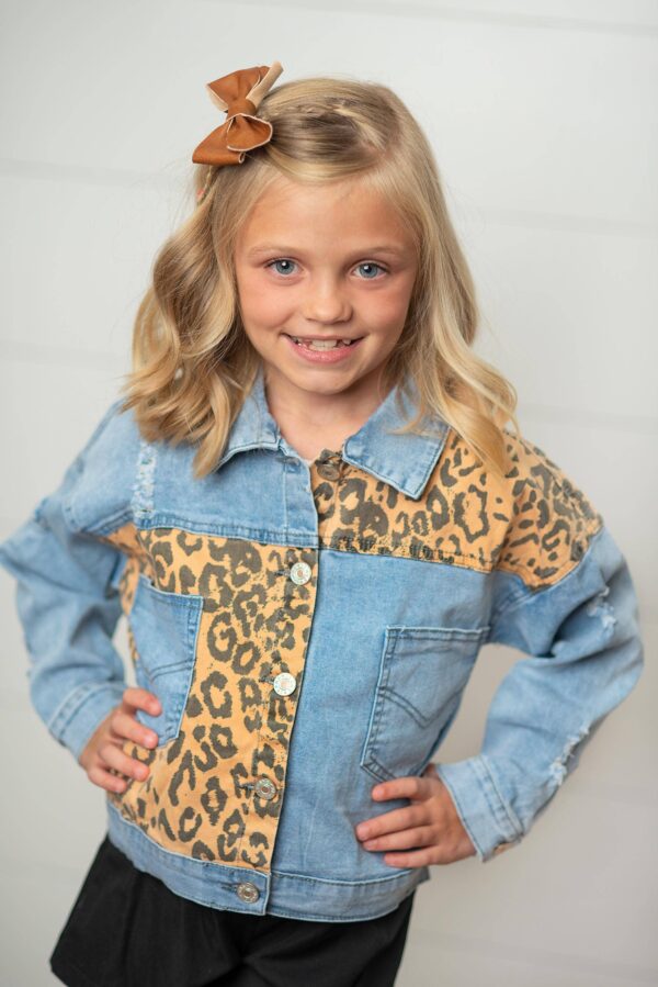 Girl wearing denim leopard print jacket smiling