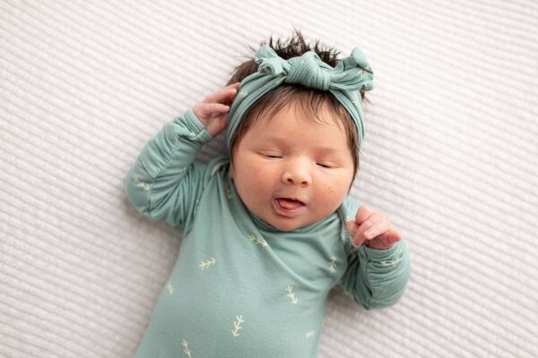 three little tots arrow print knotted newborn baby gown pajamas Sleeping baby in green outfit and headband.