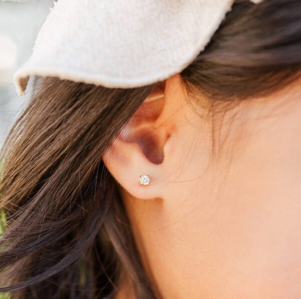 Woman wearing diamond stud earring.