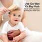 Baby brushing hair with wooden brush.
