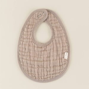 Beige textured baby bib with snaps.