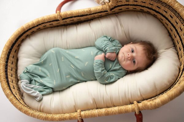 three little tots arrow print knotted newborn baby gown pajamas Baby in green swaddle laying in basket