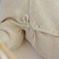 Beige knit fabric with buttons and ties.