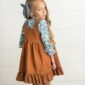 Girl wearing brown dress with blue floral shirt