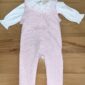 Pink baby romper with white ruffled collar.