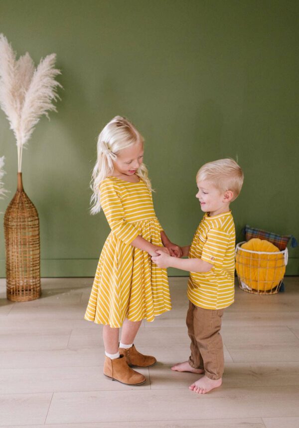 Smiling kids in matching yellow striped outfits.