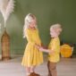 Smiling kids in matching yellow striped outfits.