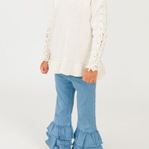 Child wearing white sweater and ruffled jeans.