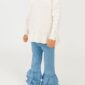 Child wearing white sweater and ruffled jeans.
