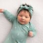 Baby in green onesie with matching headband