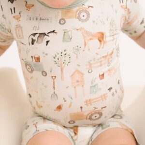 Baby wearing farm-themed patterned romper