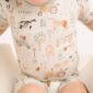 Baby wearing farm-themed patterned romper