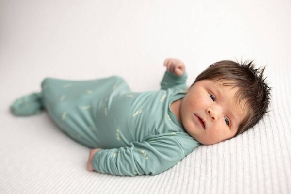 three little tots arrow print knotted newborn baby gown pajamas Newborn baby in blue sleeping on white blanket.