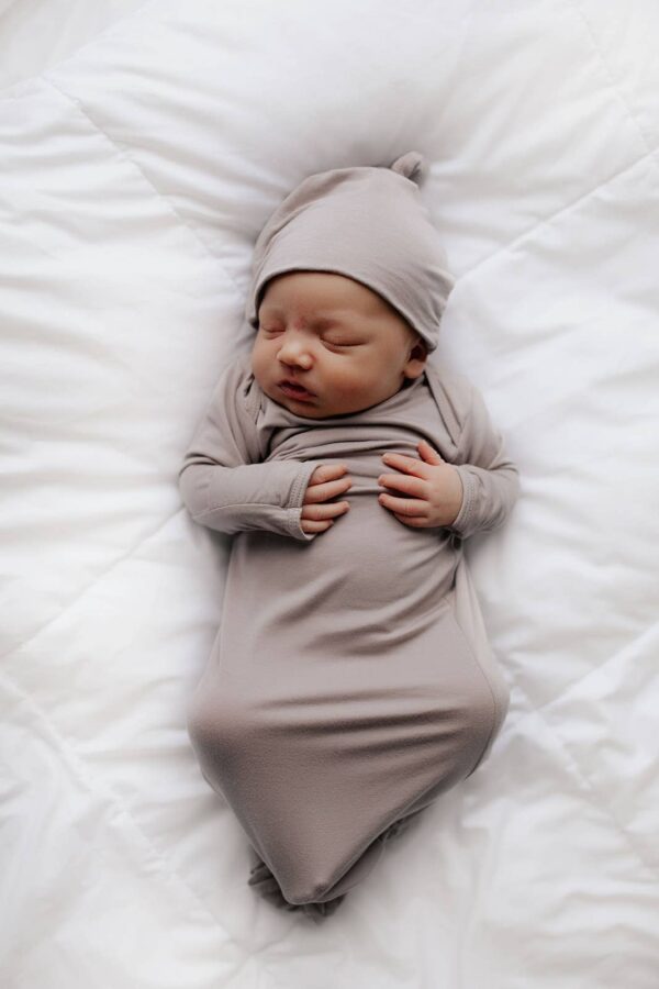 three little tots harbor mist taupe knotted gown Newborn baby sleeping wrapped in gray blanket.