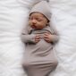 Newborn baby sleeping wrapped in gray blanket.