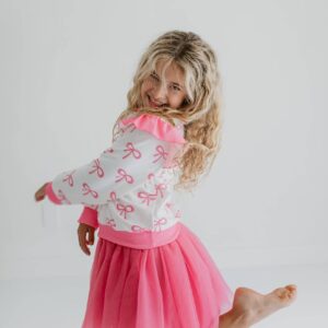 Smiling girl in pink tutu and bow sweater