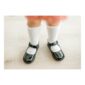 Child's legs in white socks and black shoes.