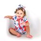 Smiling baby in colorful patterned outfit and headband.