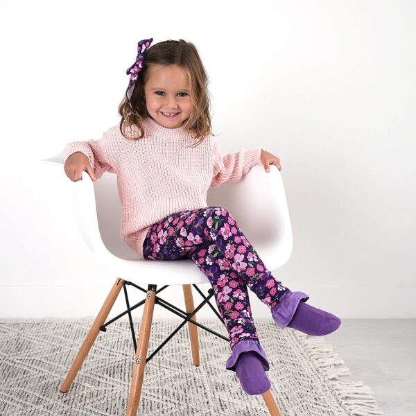 gigi and max mila leggings and sweater set Child sitting in chair wearing floral pants.