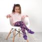 Child sitting in chair wearing floral pants.