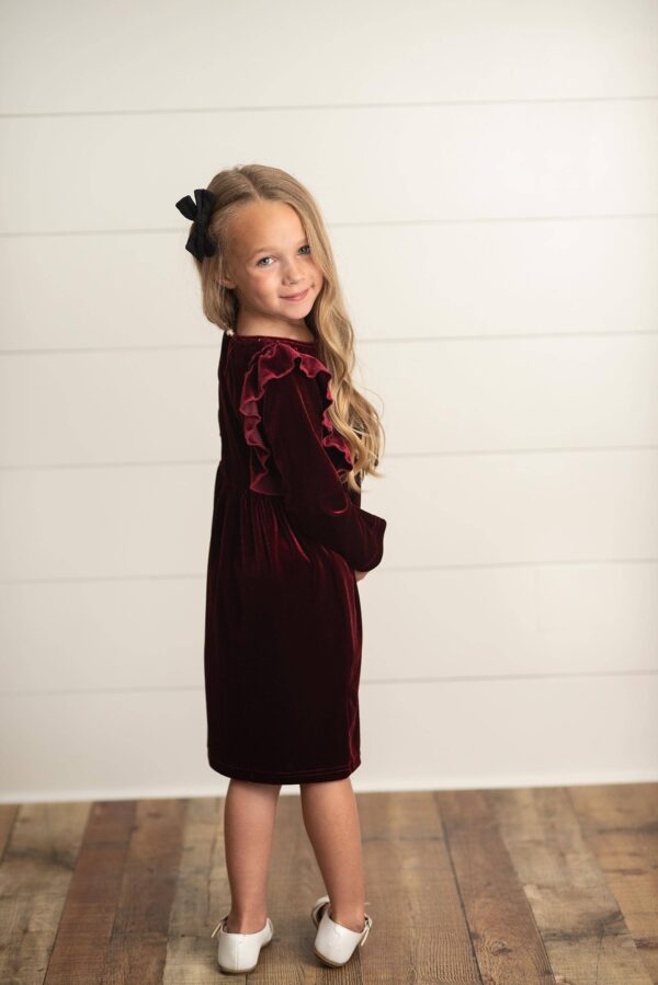 oopsie daisy kids burgundy wine velvet bow ruffle holiday party dress Girl in maroon dress with long hair and bow.