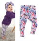Baby in floral outfit with headband.
