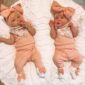 Two babies in matching peach outfits with bows