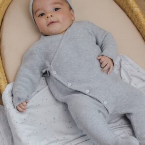 Baby in gray onesie on soft blanket