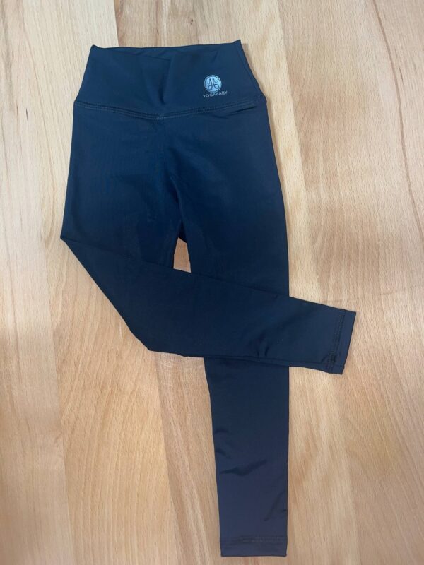 Black leggings on wooden floor.