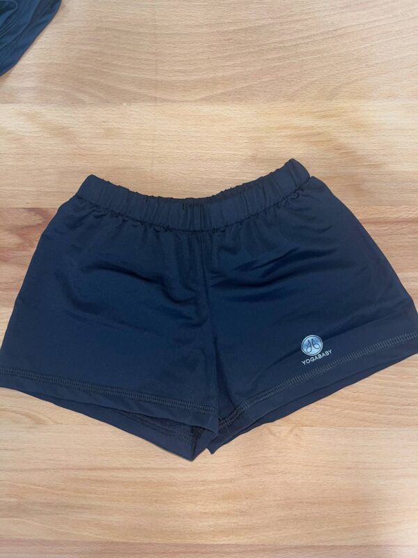 Black yoga shorts on wooden surface.
