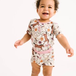 Smiling baby in floral printed romper.