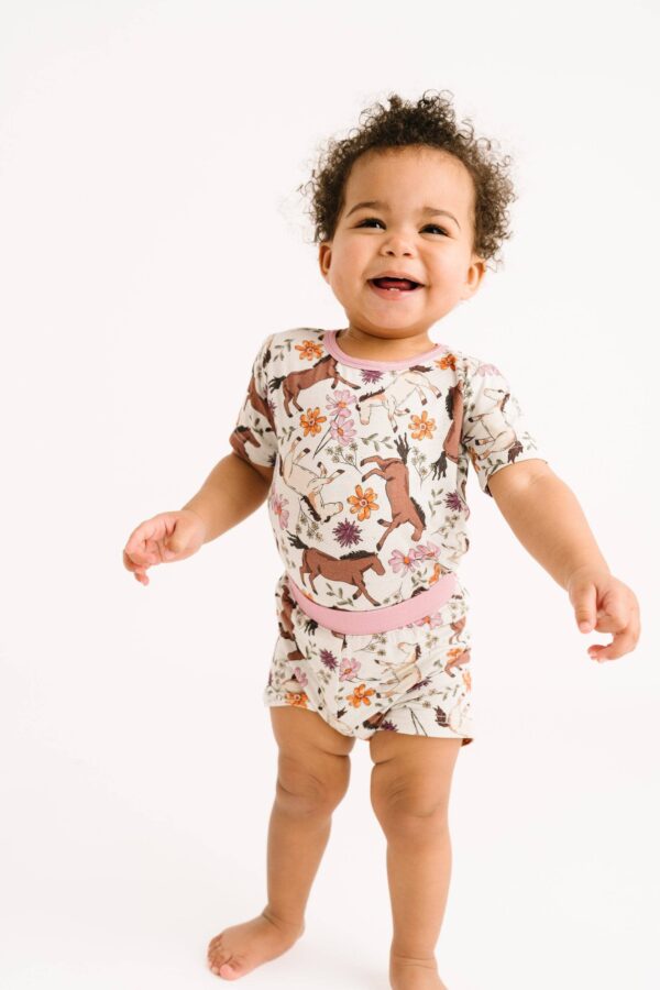 Smiling baby in floral printed romper.