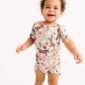 Smiling baby in floral printed romper.