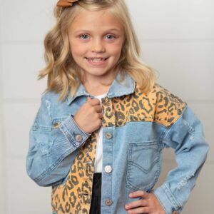 Smiling girl in leopard print denim jacket.