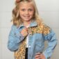 Smiling girl in leopard print denim jacket.