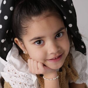 Smiling girl with polka dot headband.