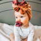 Baby with pacifier and colorful headwrap